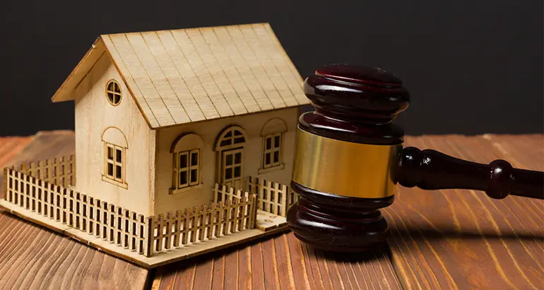 Miniature house model with legal gavel representing expert witness proceedings